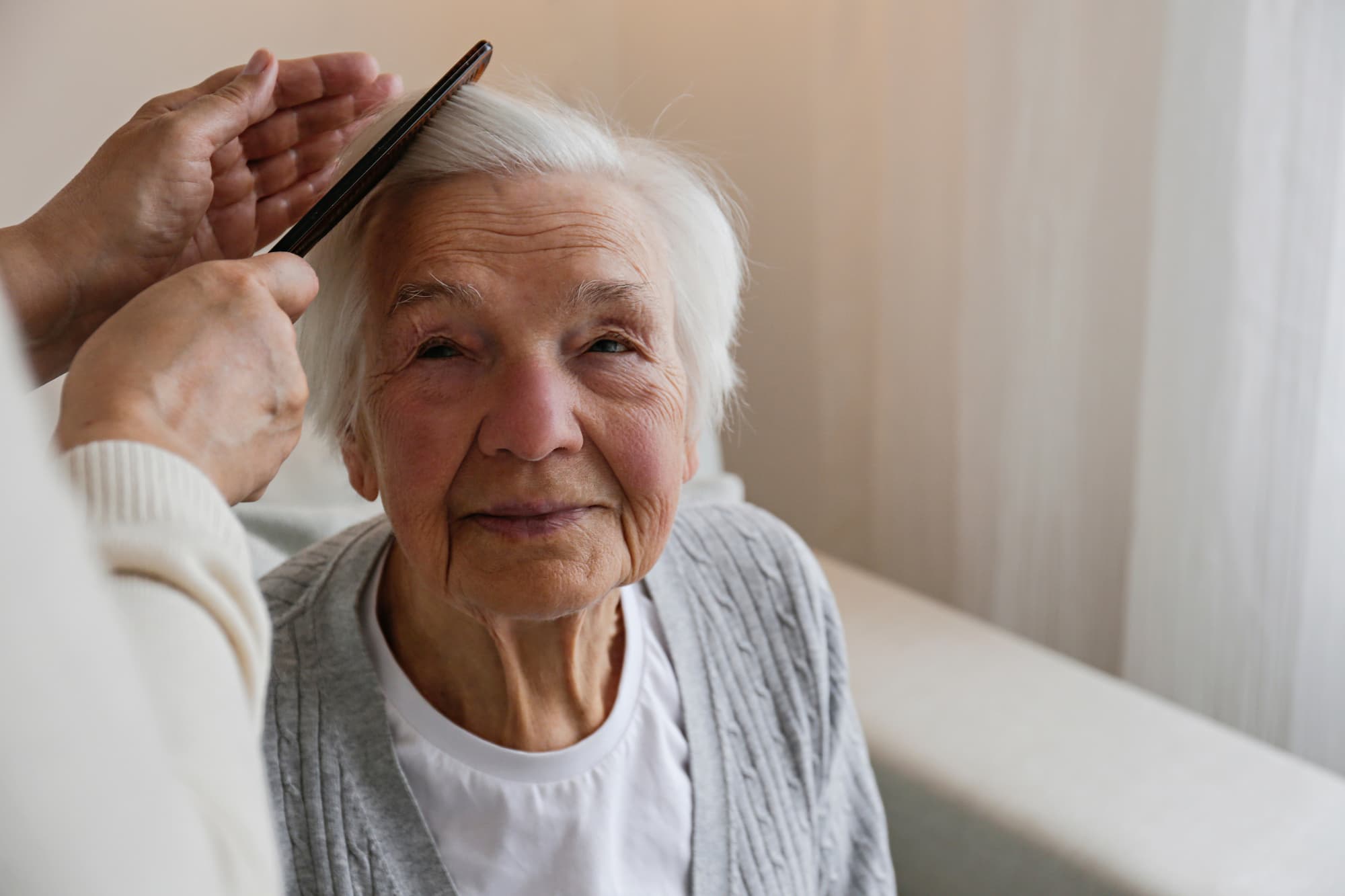 Elderly lady getting her hair combed